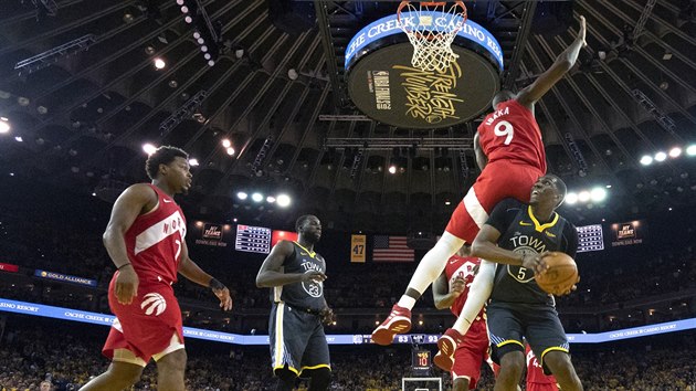 Serge Ibaka z Toronta (s slem 9) fauluje Kevona Looneyho z Golden State.