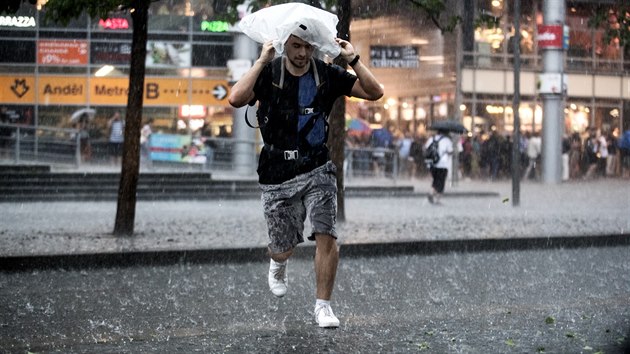 Lidé se utíkají schovat před deštěm v Praze na Andělu. (6. června 2019)