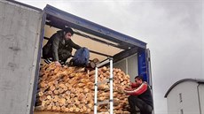 Tři muži se skrývali v nízkém prostoru mezi nákladem dřevních kulatin a... Tři muži se skrývali v nízkém prostoru mezi nákladem dřevních kulatin a...
