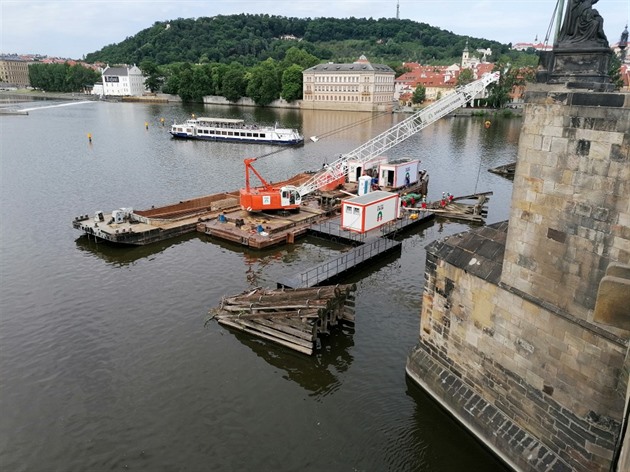 V těchto dnech probíhá odstraňování starých dřevěných zátaras na Vltavě u Karlova mostu které dříve chránily most před ledem.
