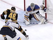 Jordan Binnington, glman St. Louis, zasahuje proti bostonskmu Davidu Krejmu.