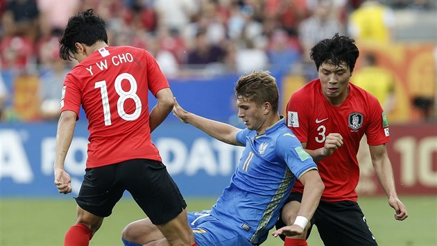 Ukrajinsk fotbalista Vladyslav Suprjaha (v modrm) bojuje s korejskou pesilou.