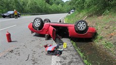 Červený kabriolet skončil koly vzhůru. Červený kabriolet skončil koly vzhůru.
