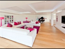 Prostorný obývací pokoj je vybavený "nekonenou" pohovkou, televizí a klavírním...