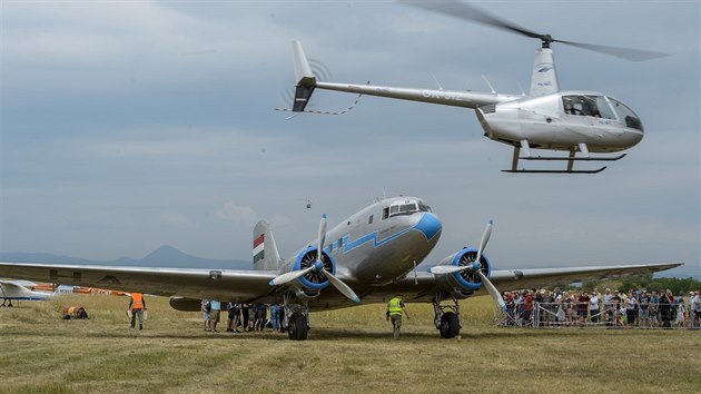 Na letiti v Roudnici nad Labem na Litomicku zaala dvoudenn leteck pehldka Memorial Air Show. Na snmku je letoun Lisunov Li-2 (vlevo) a vrtulnk Robinson R44 pi vyhldkovm letu (22. ervna 2019).