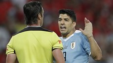 Uruguayský útoník  Luis Suárez agituje u brazilského sudího Raphaela Clause...