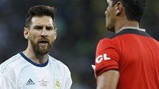 Natvaný Lionel Messi se vyítav dívá na ekvádorského rozhodího Roddyho...