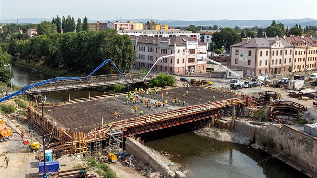 Stavai betonuj nosnou konstrukci mostu na Komenskho ulici v Olomouci. Most mus bt vybetonovan bez peruen najednou, domchvae vozily beton ze dvou betonren. Konstrukce spolkne piblin 1400 kubk betonu. Stavba novho mostu je soust budovn protipovodov ochrany v Olomouci. (19. ervence 2019)