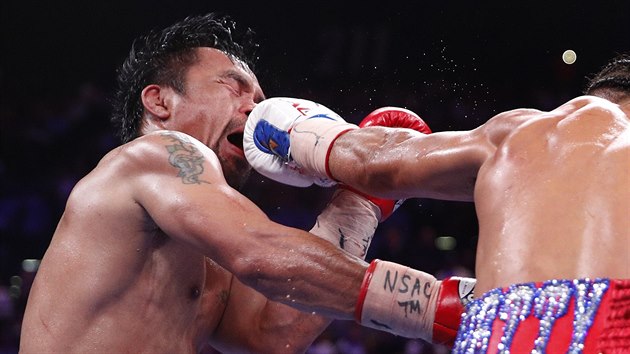 Manny Pacquiao (vlevo) inkasuje tvrd der od Keithe Thurmana v souboji o titul mistra svta organizace WBA ve velterov vze.