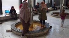 Snímek zachycující dvě cizinky, které si omývají nohy v pítku karlovarského... Snímek zachycující dvě cizinky, které si omývají nohy v pítku karlovarského...