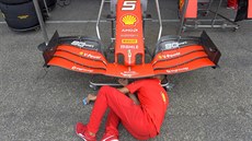 Jeden z mechaniků stáje Ferrari nastavuje vůz Sebastiana Vettela. Jeden z mechaniků stáje Ferrari nastavuje vůz Sebastiana Vettela.