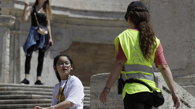 Policistka d dvku, aby nesedla na panlskch schodech, jedn z nejvtch turistickch atrakc italskho ma. (7. srpna 2019)