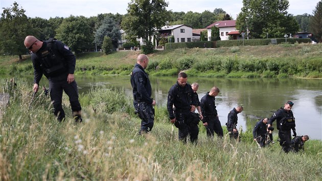 Policist prohledvaj okol domu v Beclavi, kde byl nalezen zavradn pr.