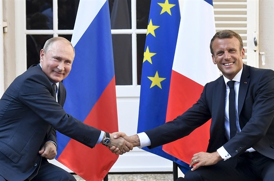 Vladimir Putin a Emmanuel Macron si podávají ruce na setkání v jiní Francii....