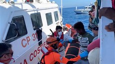 Italská pobení strá pomáhá migrantm ven z lodi. (17. srpna 2019)