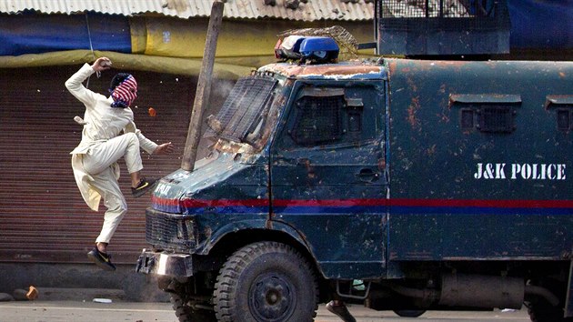 Jeden z maskovanch demonstrant ske s kamenem v ruce na policejn obrnn vozidlo bhem protest v severoindickm rnagaru. (31. kvtna 2019)