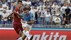 Ciro Immobile z Lazia Řím (v modrém) střílí na branku AS Řím. Ciro Immobile z Lazia Řím (v modrém) střílí na branku AS Řím.