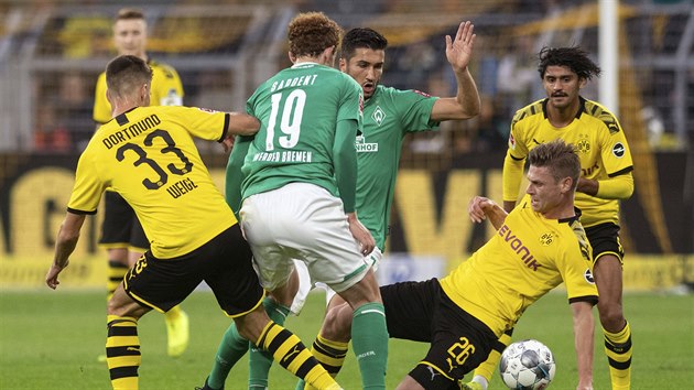 Julian Weigl (vlevo) z Dortmundu a jeho spoluhráč Lukasz Piszczek se snaží obrat o míč Josha Sargenta z Brém.
