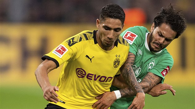 Achraf Hakimi z Dortmundu ve žlutém kontroluje balon před Leonardem Bittencourtem z Brém.