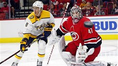 Brankář Caroliny James Reimer sleduje letící puk, před ním číhá Kyle Turris z... Brankář Caroliny James Reimer sleduje letící puk, před ním číhá Kyle Turris z...