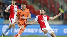 Obránce Slavie David Hovorka ve skluzu ped Meanoviem z Mladé Boleslavi.