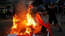 Protivládní demonstranti v centru Hongkongu pálí plakáty oslavující 70. výroí...