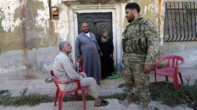 Syrt povstalci prochzej mstem Tal Abjd na kurdskm severu Srie pot, co jej spolu s tureckou armdou dobyli. (13. jna 2019)