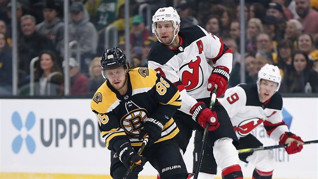 David Pastrk z Bostonu ujd za pukem, za nm Travis Zajac z New Jersey.