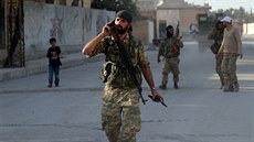 Syrtí povstalci procházejí mstem Tal Abjád na kurdském severu Sýrie poté, co...
