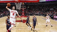 Zach LaVine (8) z Chicaga smeuje do koe New Orleans, sleduje ho spoluhrá...