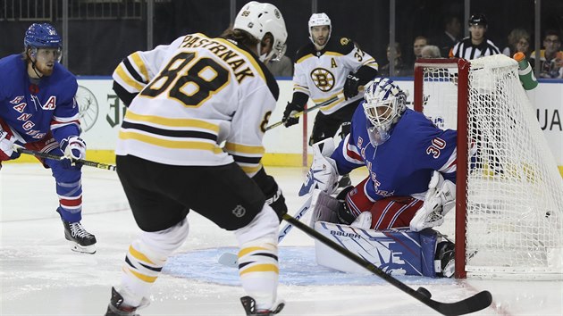 tonk Bostonu David Pastrk zkou vyzrt na Henrika Lundqvista v brance NY Rangers.