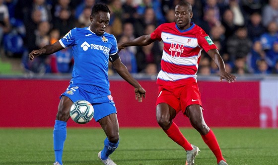 Djene Dakonam (vlevo) z Getafe v souboji s Adrianem Ramosem z Granady.