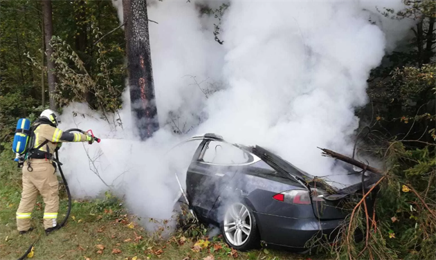 Hoící elektromobil znaky Tesla hasilo na padesát hasi. (4. íjna 2019)