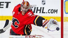 David Rittich z Calgary se natahuje po puku.