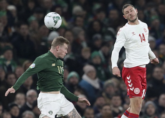 James McClean (vlevo) z Irska hlavikuje v duelu s Dánskem, bojuje s ním Henrik...