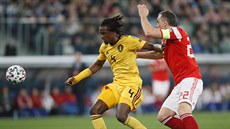 Belgian Dedryck Boyata (vlevo) se snaí udret balon ped ruským útoníkem...