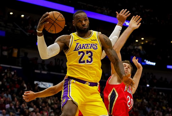 LeBron James (23) z LA Lakers zachytil pihrávku a útoí kolem Nicola Melliho z...