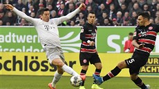 Robert Lewandowski z Bayernu Mnichov (vlevo) a Kaan Ayhan z Düsseldorfu bojují...