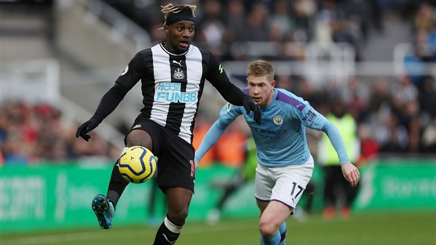 Allan Saint-Maximin (vlevo) z Newcastlu hraje s balonem, sth jej Kevin De Bruyne z  Manchesteru City.