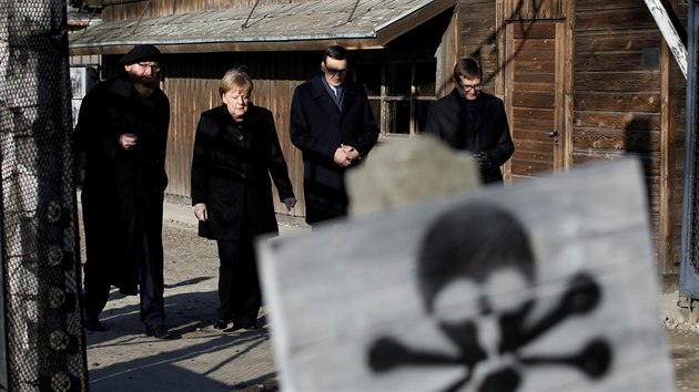 Nmeck kanclka Angela Merkelov v doprovodu polskho premira Mateusze Morawieckho (po jej levici) vchz do bvalho koncentranho tbora v Osvtimi. (6. prosince 2019)