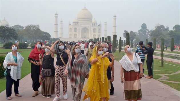 Turist v roukch prochzej arelem slavn hrobky Td Mahal v indick ge. (listopad 2019)