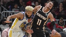 Trae Young (11) z Atlanty atakovaný Ky Bowmanem z Golden State.