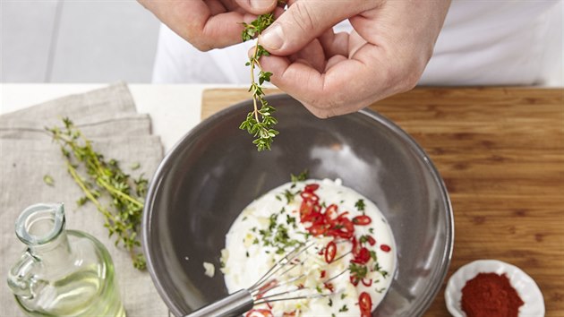 V míse pak vše promícháme se zakysanou smetanou, solí, pepřem, otrhanými lístečky tymiánu, kari a mletou paprikou.