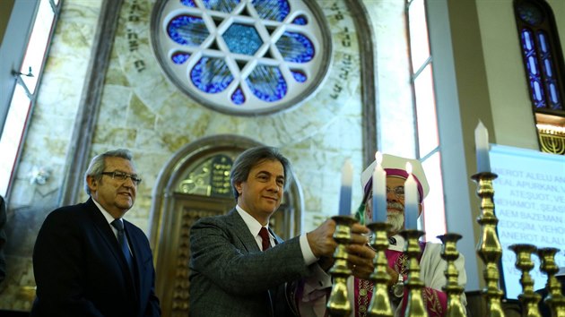 Starosta istanbulsk tvrti Beyoglu Ahmet Misbah Demircan zapaluje svci v tamn synagoze. (27. prosince 2016)