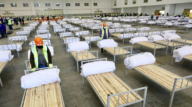 Pracovnci pemuj kongresov sl na provizorn nemocnici v Wu-chanu. na se potk s epidemi koronaviru, nakaench je u pes 20 000 lid. (4. nora 2020)
