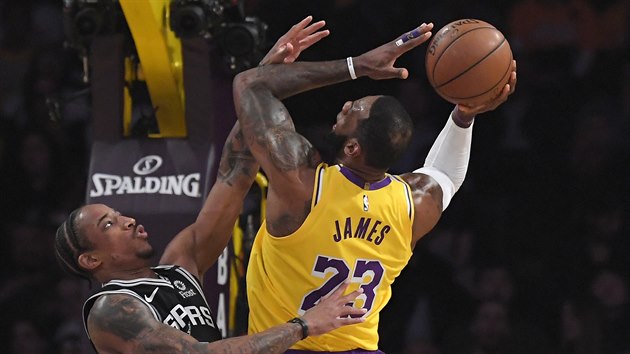 LeBron James z Los Angeles Lakers  zakonuje pes brncho DeMara DeRozana ze San Antonia.