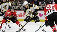 David Pastrňák z Bostonu u puku, přibrzdit se ho snaží , David Kämpf a Erik... David Pastrňák z Bostonu u puku, přibrzdit se ho snaží , David Kämpf a Erik...