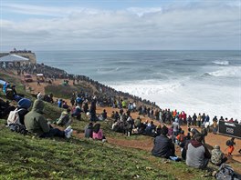 Publikum sleduje surfae v portugalském Nazaré. Místo je milovníky tohoto...