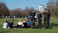 Mnichovští policisté upozorňují mladé lidi v parku, aby dodržovali dostatečný... Mnichovští policisté upozorňují mladé lidi v parku, aby dodržovali dostatečný...