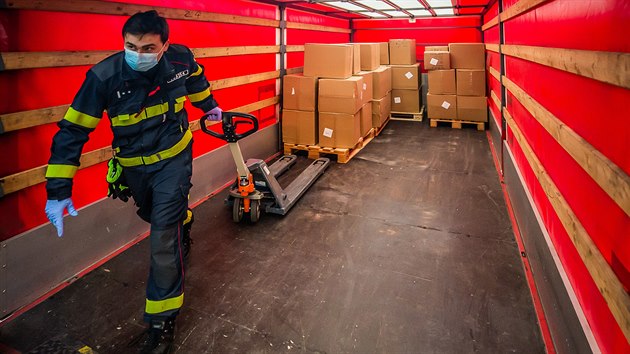 Hasiči v policejním skladu v Opočínku u Pardubic třídí zdravotnický materiál, který v noci na neděli dopravil velkokapacitní ukrajinský letoun An-124 Ruslan z čínského Šen-Čenu. (22. března 2020)